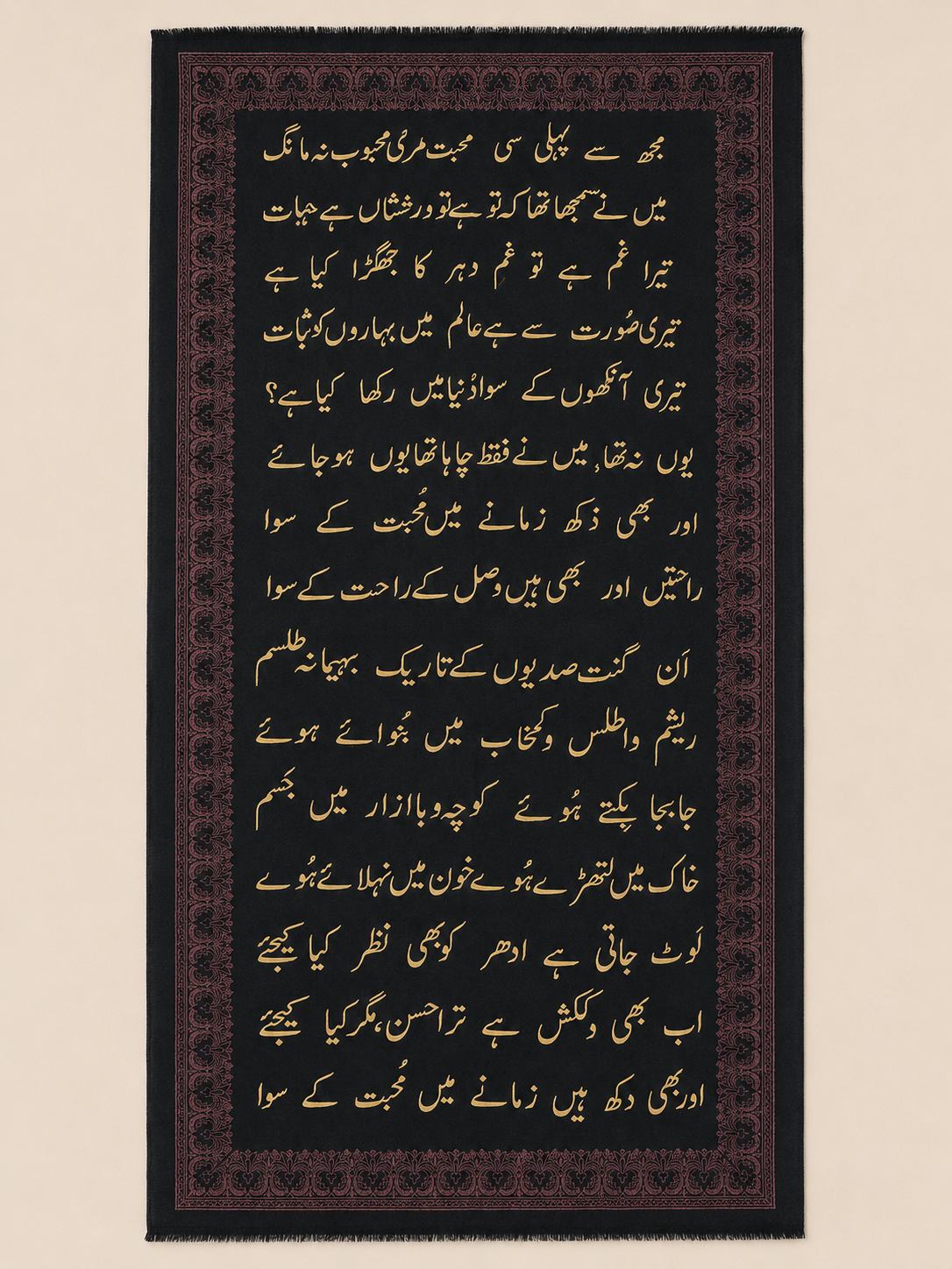 Black pashmina shawl with muted rose calligraphy-motif border and gold Urdu script, shown in flat-lay.