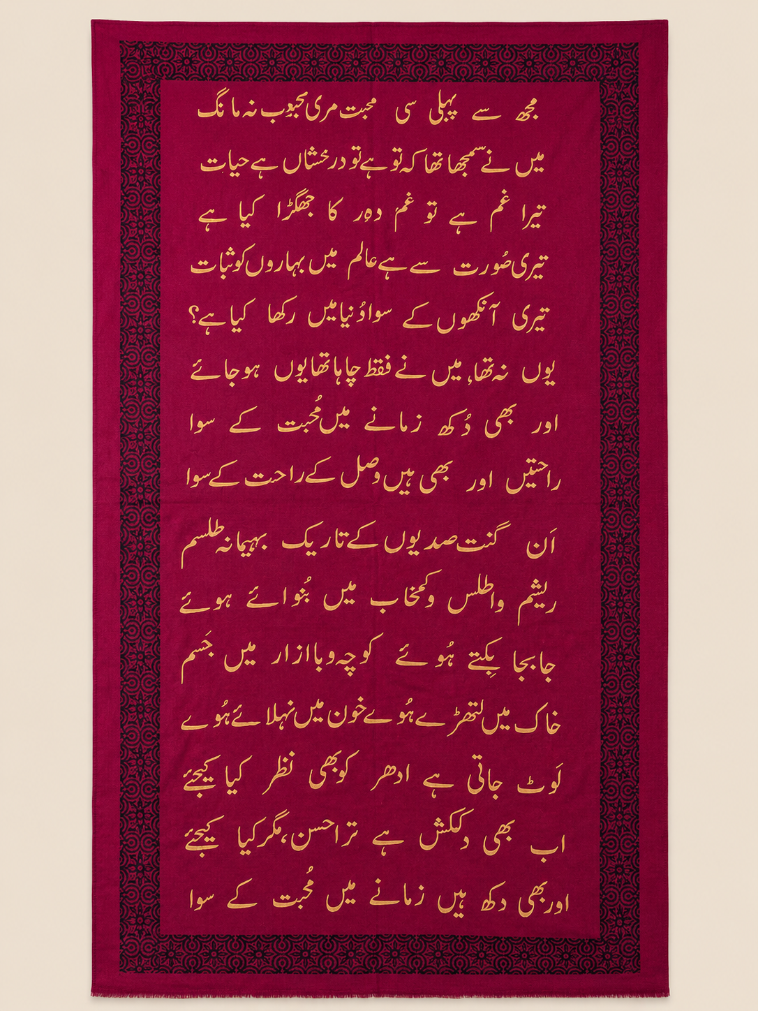 Deep maroon pashmina shawl with dense black calligraphy-motif border and gold Urdu script, shown in flat-lay.